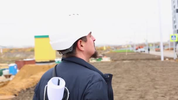 construction engineer or architect in helmet with a construction plan on the construction site. - Séquence, vidéo