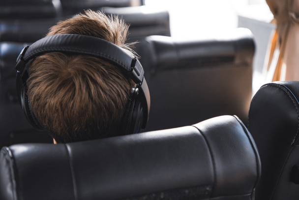 rear view of male tourist in headphones listening music during trip on travel bus  - Zdjęcie, obraz