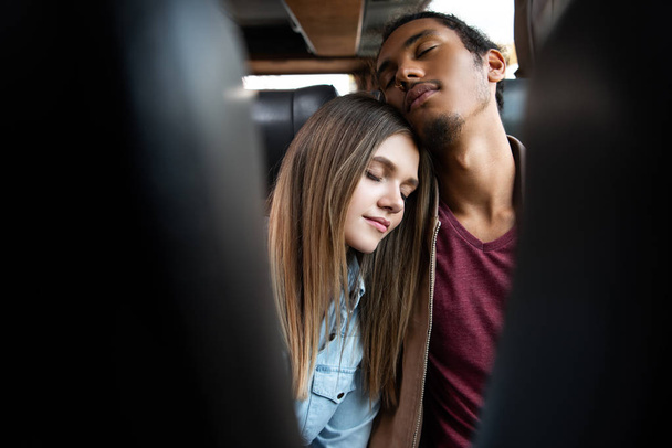 旅行バス旅行中に寝ている若い異人種間カップルの選択と集中 - 写真・画像