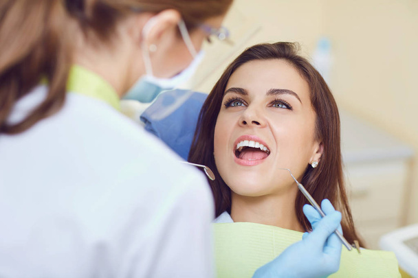 A girl with a beautiful smile with a dentist. - Zdjęcie, obraz