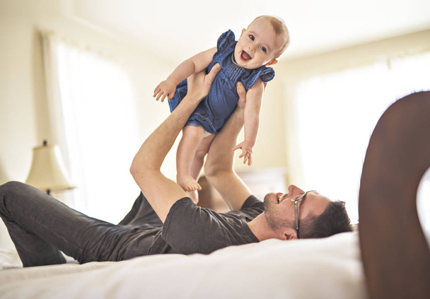Father playing with her baby in the bedroom - Foto, Imagen