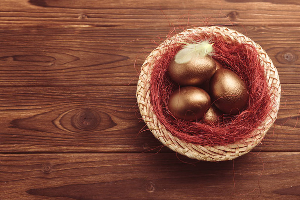 gold easter eggs on wooden table - Zdjęcie, obraz