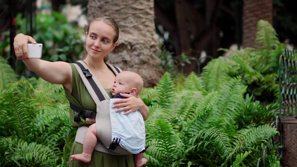 スマート フォンと旅行赤ちゃんと若い母親. - 映像、動画