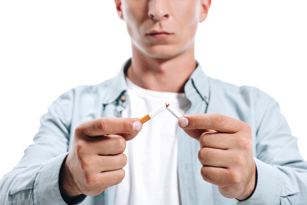 rajattu kuva mies rento vaatteet murtaa epäterveellistä savuketta eristetty valkoinen
 - Valokuva, kuva