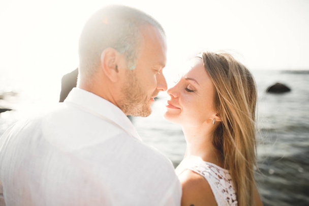 Щасливі щойно одружилися молода весільна пара святкує і розважається на красивому пляжному заході сонця
 - Фото, зображення