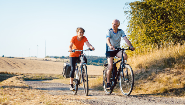 Старшая пара ездит на велосипедах для улучшения физической формы
 - Фото, изображение