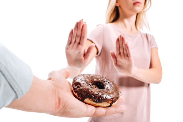 imagen recortada de mujer rechazando donut de chocolate aislado en blanco
 - Foto, Imagen