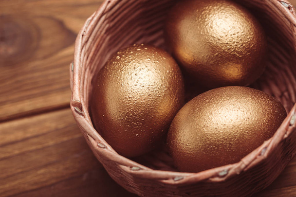 gold easter eggs on wooden table - Foto, Imagem