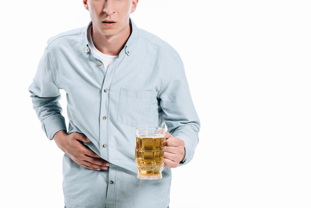 cropped image of man showing stomach pain and holding glass of beer isolated on white - Фото, зображення