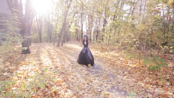 Zombie-Mädchen spaziert durch den Herbstwald. auf ihrem Gesicht ist das Make-up des Schädels für den Halloween-Feiertag. - Filmmaterial, Video