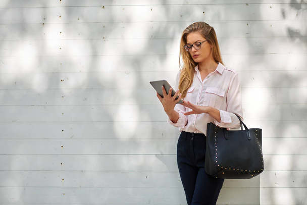 Businesswoman standing outdoors and using tablet. - Foto, imagen