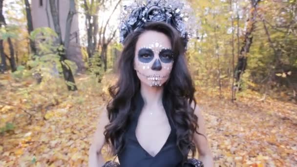 Egy gyönyörű zombi nő portréja közelről. Smink díszíti strasszokkal, Halloween. - Felvétel, videó