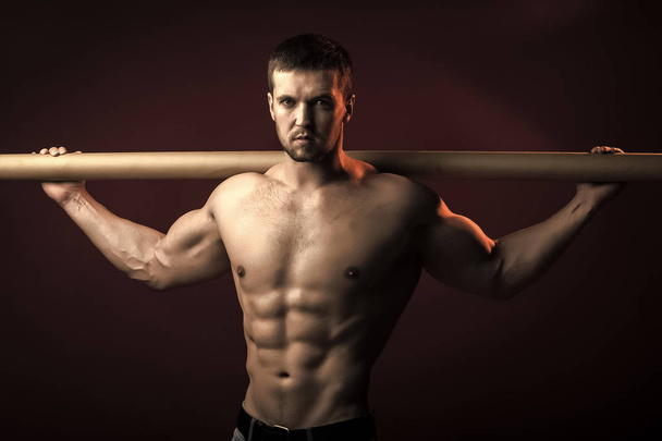 Muscular man with crossbar - Фото, изображение