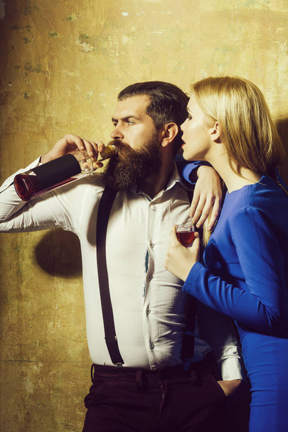 Girl with glass of liqueur looking at man drinking wine - Foto, imagen
