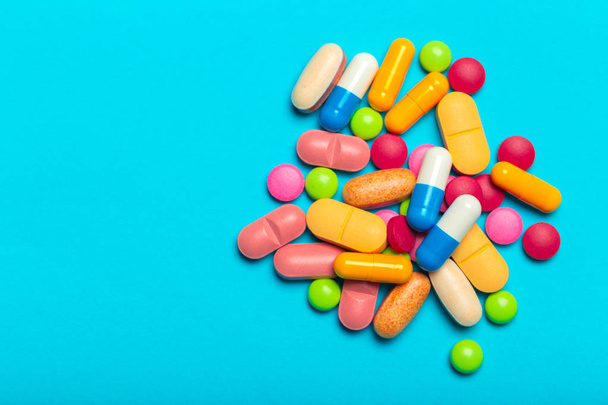 Pills scattered over blue background - Foto, afbeelding