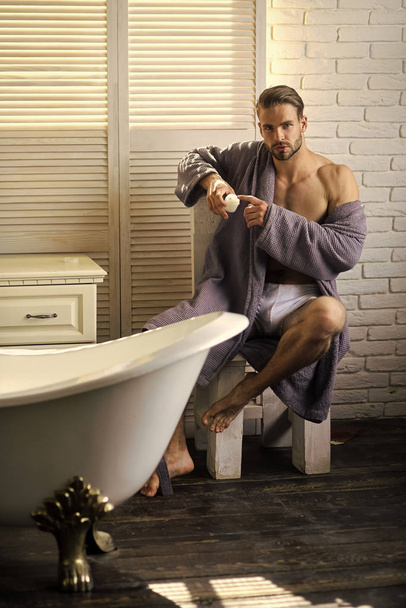 Gay with wax in bathrobe in bathroom - Valokuva, kuva