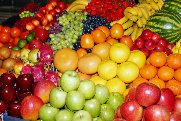 Achtergrond van vers geplukte appels, peren, bananen, druiven, aardbeien, veenbessen, citroenen, meloenen, frambozen, krenten, bramen, perziken, kruisbessen, abrikozen, perziken - Foto, afbeelding