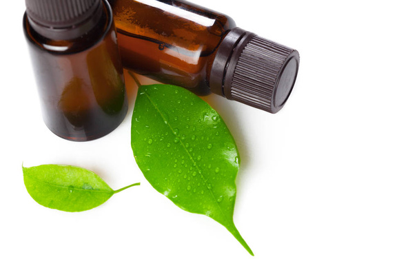 Nahaufnahme von Wellness-Öl und Blättern auf weißem Hintergrund - Foto, Bild