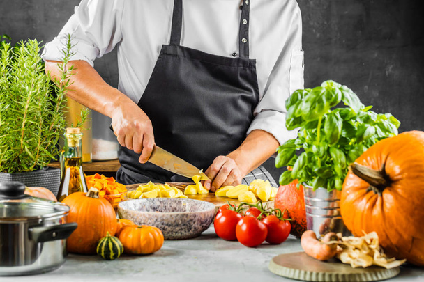 Chef cook preparing vegetables in his kitchen - Фото, изображение