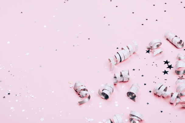 Silver sparkles, stars and glitters on pink background. Festive concept. - Foto, afbeelding