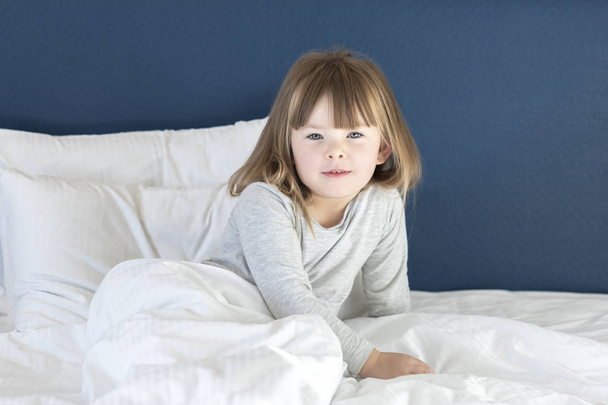 Imádnivaló lány nyújtózkodik az ágyon - Fotó, kép