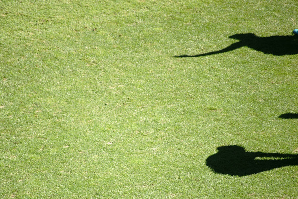 Rozgrzewki ćwiczenia na boisko / cienie piłkarzy w rozgrzewki ćwiczenia na zielono trawa pole boisko do piłki nożnej - Zdjęcie, obraz