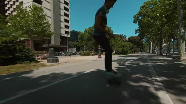Young man rides longboard in park - Video, Çekim