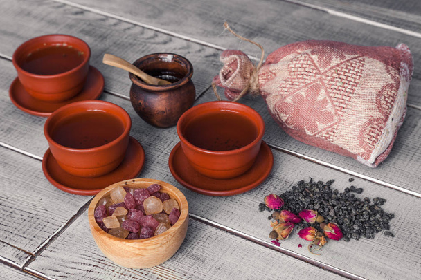 Ceremonia del té, fiesta del té. Tazas, miel, azúcar y saco de tela vintage en una mesa de madera. Concepto de un delicioso desayuno saludable
 - Foto, Imagen