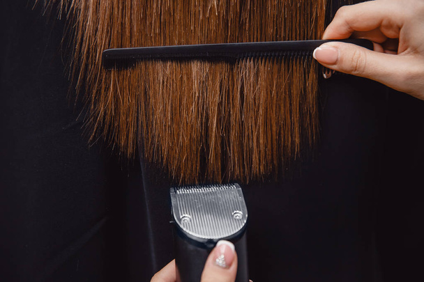 Master combs hair with his teeth in salon - Valokuva, kuva