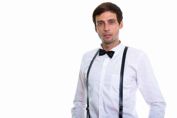 Studio shot of young handsome man wearing suspenders and bow tie - Foto, Imagem