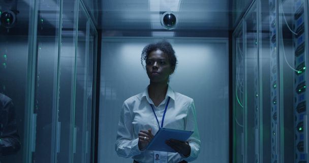 Femme noire avec tablette travaillant dans la salle de serveur
 - Photo, image