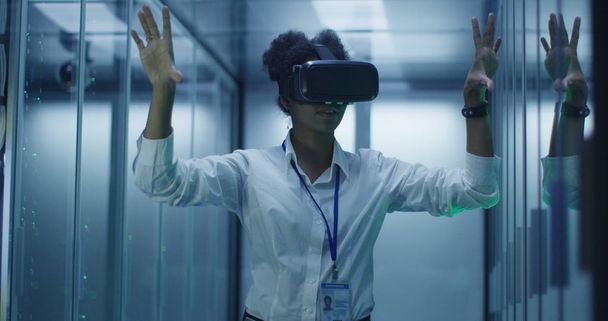 Етнічна жінка в окулярах VR, що працюють в центрі обробки даних
 - Фото, зображення