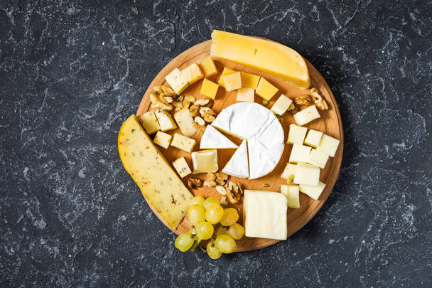 暗い石のテーブル、平面図上にチーズの様々 な種類 - 写真・画像