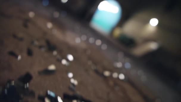 Glass shards of broken bottle on ground, silhouettes of people in inner yard. - Footage, Video