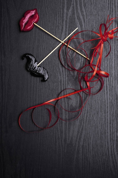 accessoires de fête carnaval bonbons femmes lèvres rouges et moustache homme sur fond noir, concept amour, homme et femmes, 14 février, désherbage
 - Photo, image