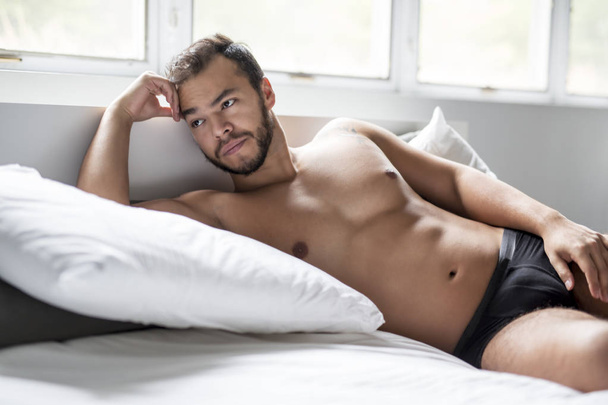 Młody człowiek z Meksyku, shirtless w białe łóżko - Zdjęcie, obraz