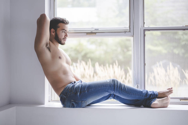 Sexy fashion portrait of a hot male model in stylish jeans with muscular body - Foto, immagini