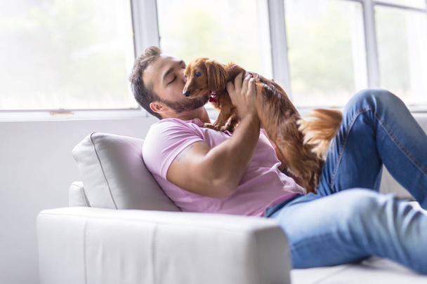 A Nice men on sofa with dog - Photo, image