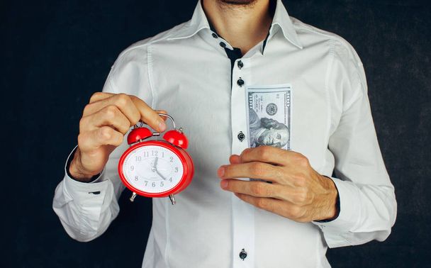 Alarm clock and human hand with money - Фото, изображение