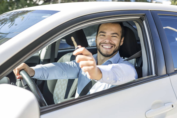 Closeup portrait, young cheerful, joyful, smiling, men holding up keys to her first new car - Фото, изображение