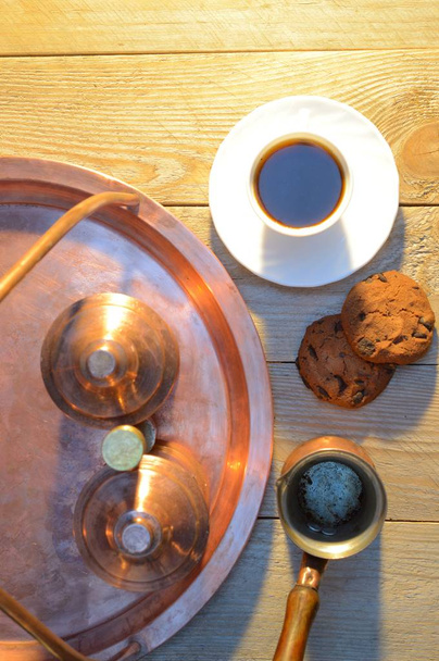 un biscuit et une tasse de café près du sucrier et un récipient avec café sur une table rustique en bois
 - Photo, image