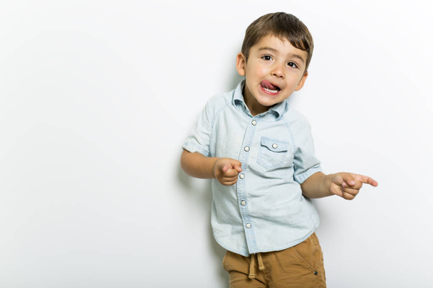 Boy having fun on studio grey background - Фото, изображение