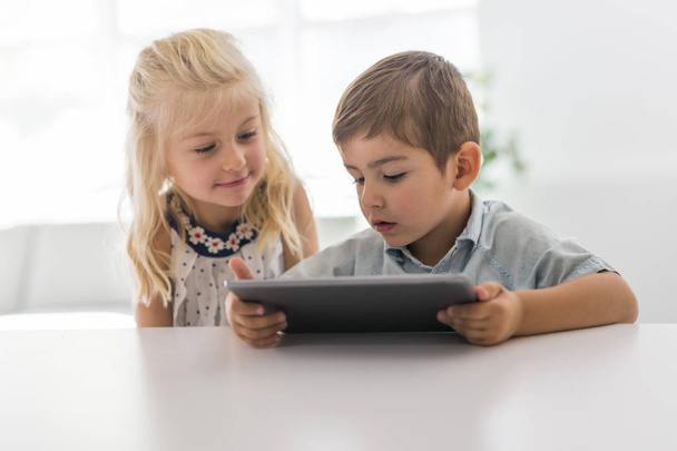 Adorable brother and sister young child using tablet - Foto, afbeelding