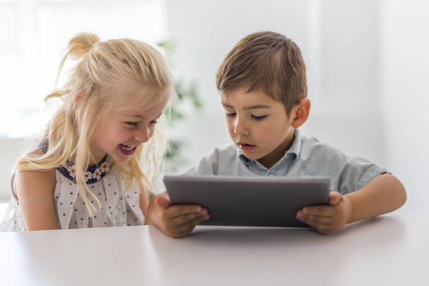 Adorable brother and sister young child using tablet - Foto, Bild