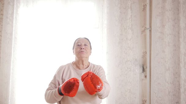 Μια ηλικιωμένη γυναίκα ανώτερος πυγμαχία γάντια κόκκινα - Φωτογραφία, εικόνα
