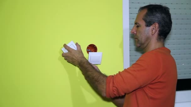 Mann installiert einen elektrischen Schalter - Filmmaterial, Video