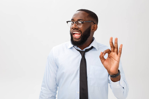 Porträt eines afrikanisch-amerikanischen Geschäftsmannes, der lächelt und ein gutes Zeichen zeigt. Körpersprache-Konzept - Foto, Bild