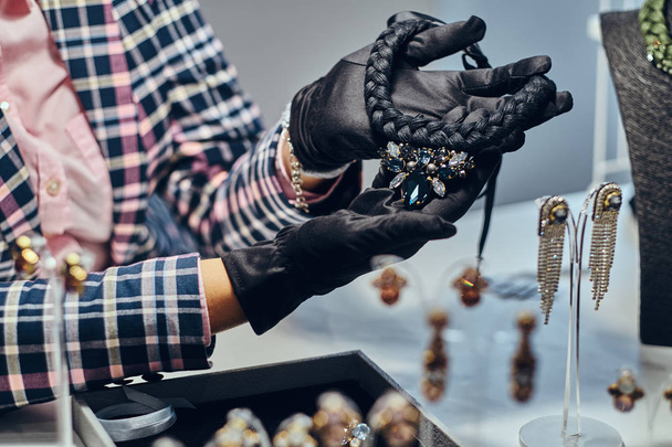 Foto ravvicinata di un gioielliere che presenta una costosa collana con pietre preziose in una gioielleria
. - Foto, immagini