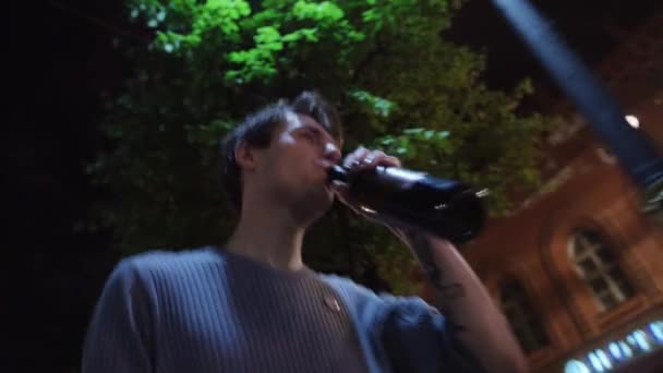 П'яний хлопець в светрі п'є з пляшки, бере папір і викидає його
 - Кадри, відео