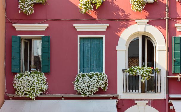 Fachada de un edificio tradicional de estilo veneciano decorado con flores
 - Foto, Imagen